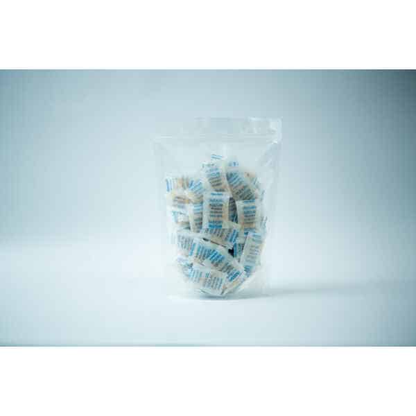 A clear plastic bag containing multiple Desiccant Silica Gel 5g | Reusable sachets stands upright against a plain white background. The sachets display blue and white text on their surface.