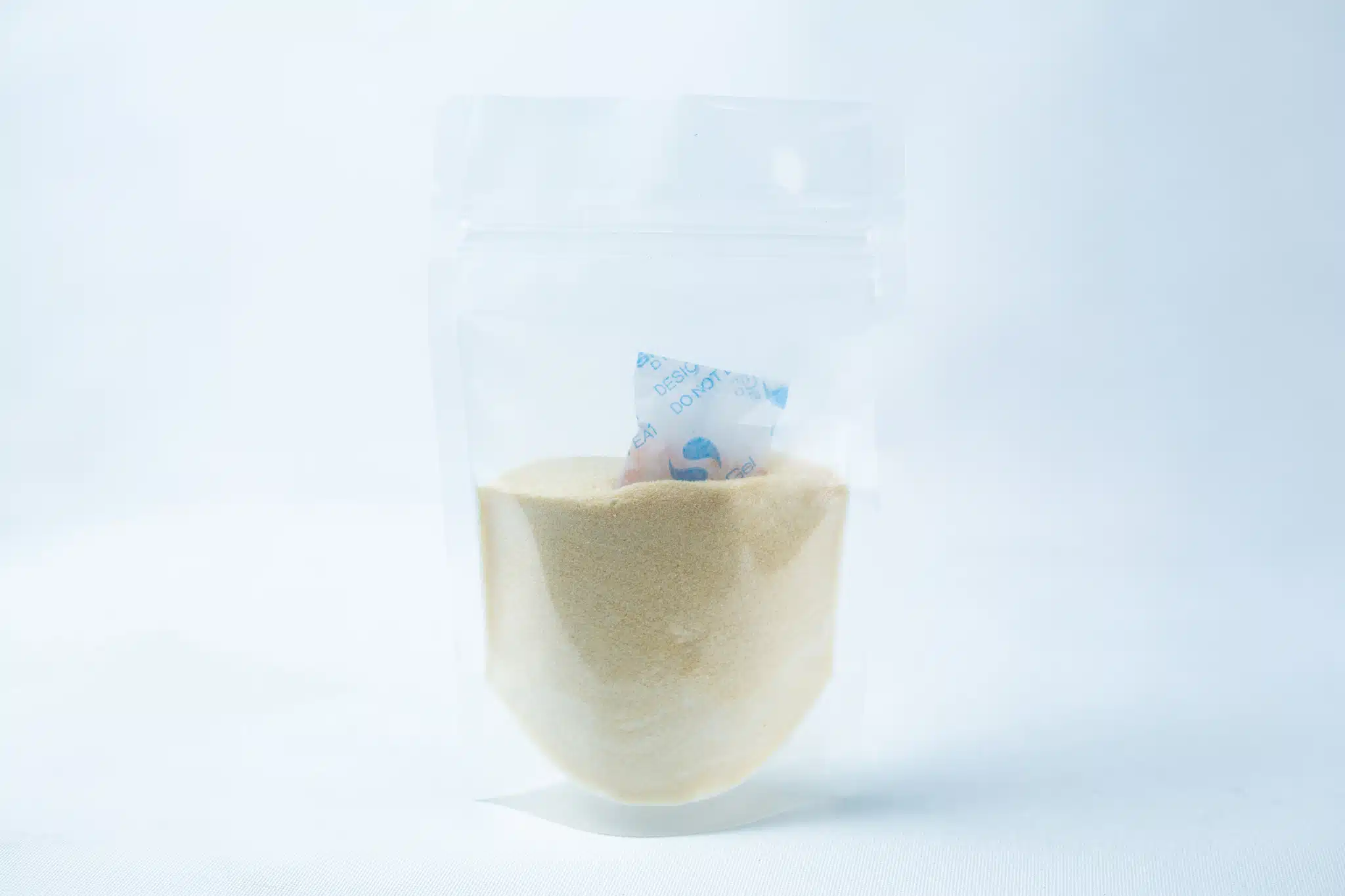 Liquid Culture Kit with Jar, Magnetic Stirrer and LC Mix 3 A clear resealable plastic bag of liquid culture mix – dextrose and light malt extract – shows light yellow powder inside, with a small blue and white desiccant sachet near the top, all set against a plain white background.