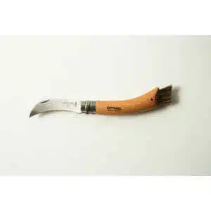 An Opinel No 8 Folding Mushroom Knife with a beech handle and stainless steel curved blade, featuring a small brush at the end, is displayed on a plain white surface.