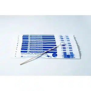 A Sterile Cotton Tip Applicator/ Swab lies on top of several blue and white packaged applicators labelled with the same product name, all arranged on a white surface.
