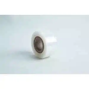 A roll of Grafting Tape to seal agar plates, clear with a brown cardboard core, stands upright on a light surface against a pale background—ideal for sealing delicate samples or agar plates.