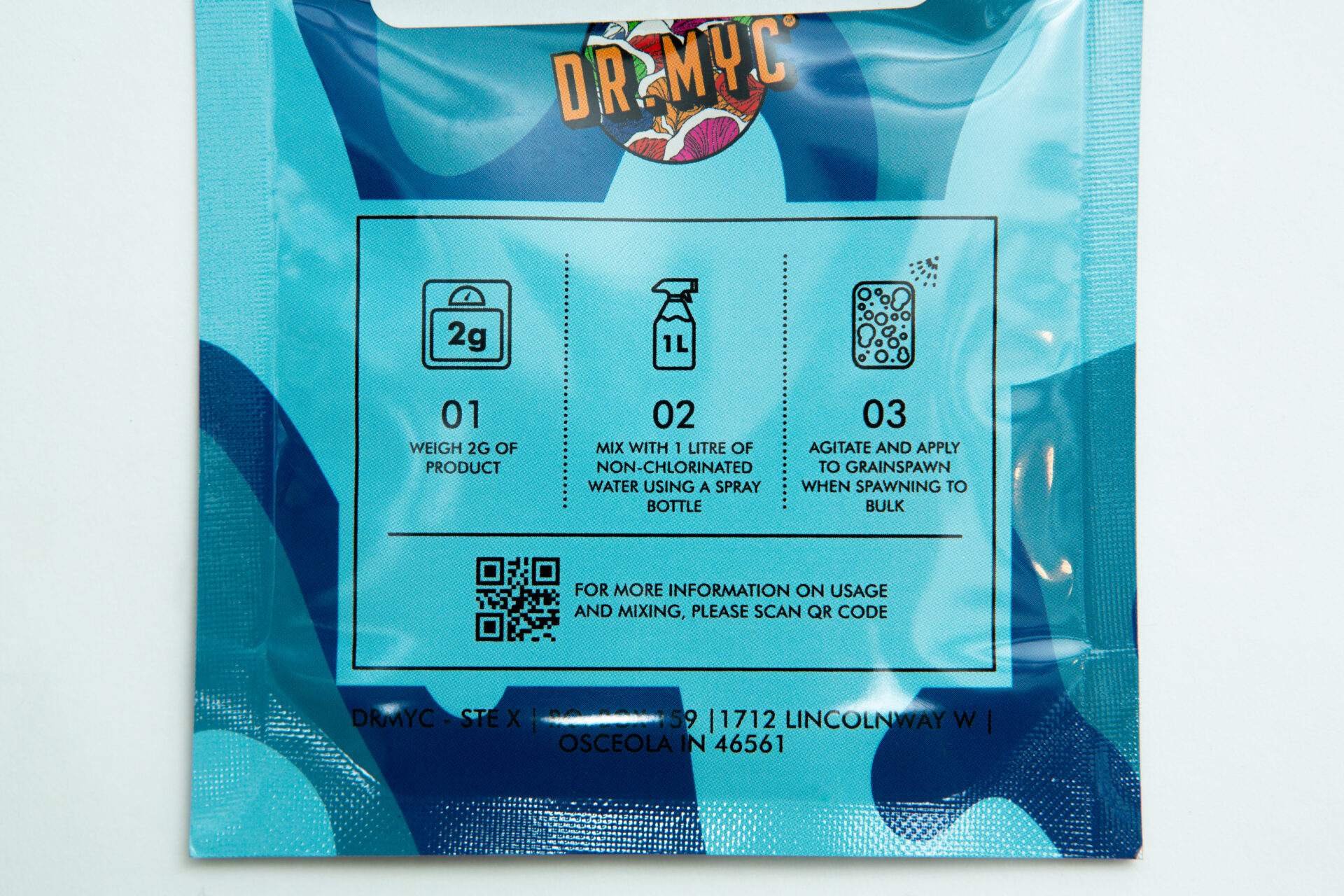 DRMyc MGP Pure - Gourmet/Medicinal Mushroom Growth Promoter 3 A close-up of a blue DRMyc Adaptive Liquid Culture Premix packet shows illustrated instructions: weigh 2g, mix with 1L water in a spray bottle, shake, spray, and scan the QR code for full liquid culture cultivation details.