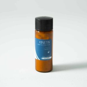 A small brown plastic bottle with a black cap and a blue label reading “Plant Cell Kinetin Powder” stands upright on a plain white surface. This plant hormone is derived from kinetin powder.