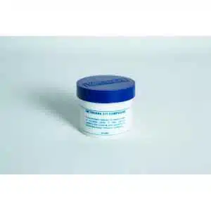 A small white plastic jar with a blue lid, labelled "Metroark Silicone Grease Lubricant High Temp Vacuum," sits on a plain white surface. The label describes it as a high-temperature silicone grease for mechanical equipment.