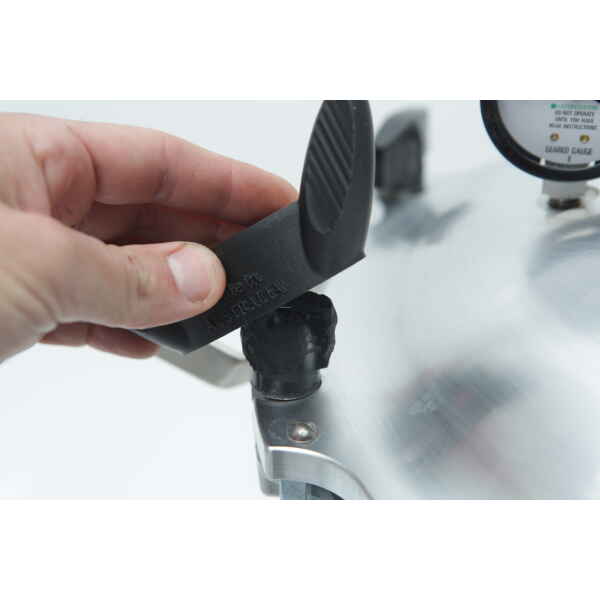 A hand uses the Rootlab Original 3D Printed Wingnut Spanner for All American Steriliser to adjust or remove a black knob on the steriliser lid, with a pressure gauge visible in the background.
