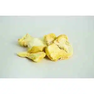 Several pieces of dried lion’s mane mushroom are arranged on a plain white surface with a neutral background. The mushrooms have a yellowish, fibrous appearance.