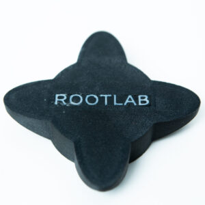 A black, four-lobed object with the word ROOTLAB printed in white capital letters on its surface, placed on a plain white background.