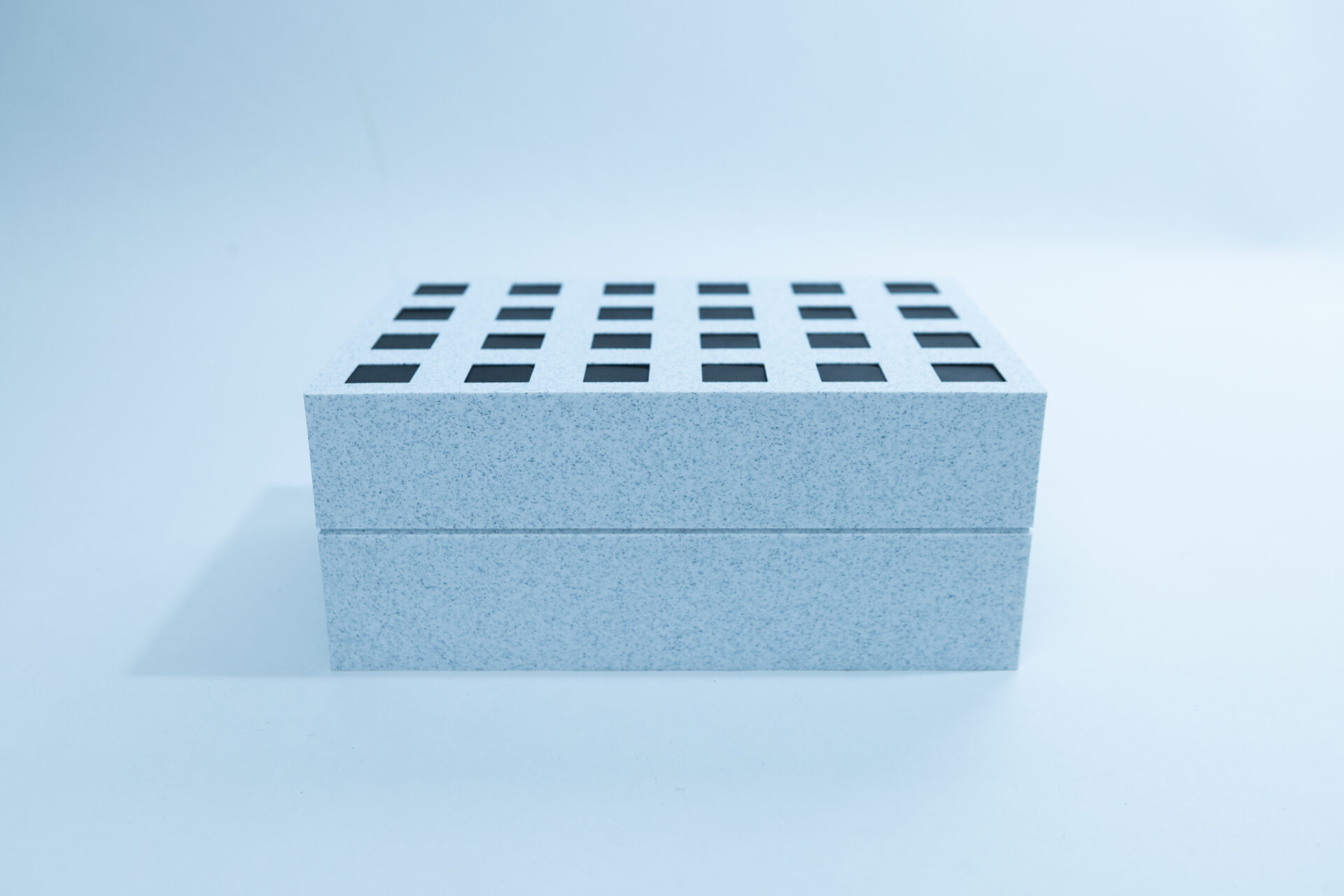 Sterile Liquid Culture Vials, Dr Myc Adaptive LC, Crimp Sealed 24 A rectangular, light grey box with a grid pattern of black squares on the top surface sits on a plain, light background.
