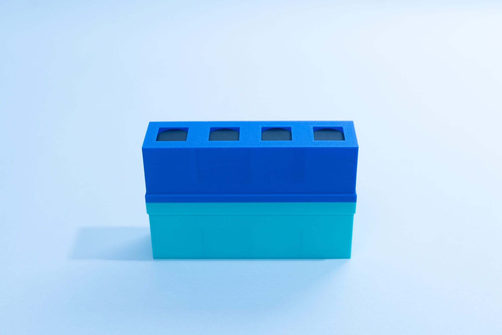 Sterile Liquid Culture Vials, Dr Myc Adaptive LC, Crimp Sealed 27 A blue and teal rectangular plastic container with five square openings on top, placed on a light blue surface with soft shadows.