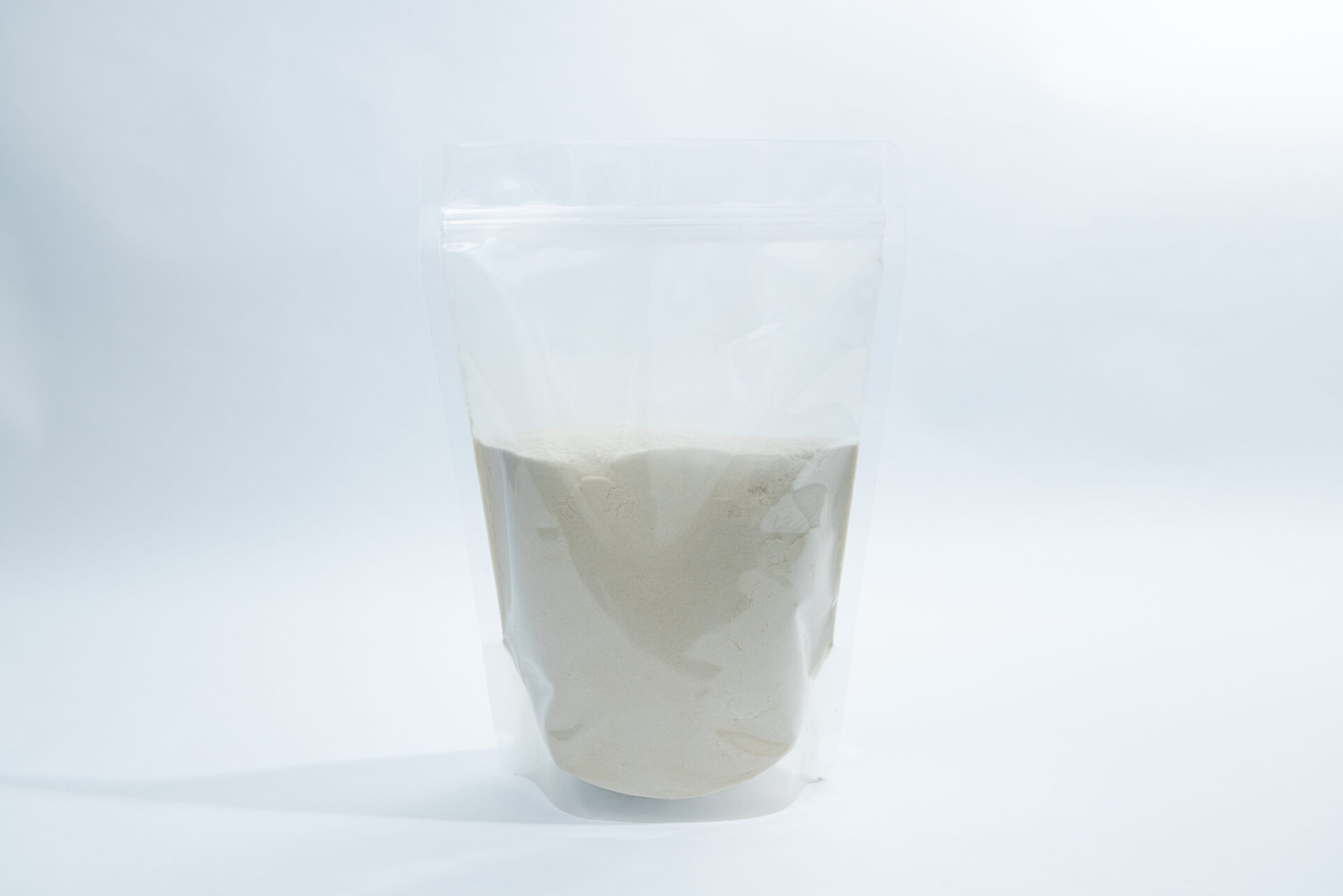 Gellan Gum High Acyl 1 A clear, resealable plastic pouch filled with a light beige powder stands upright against a plain white background.