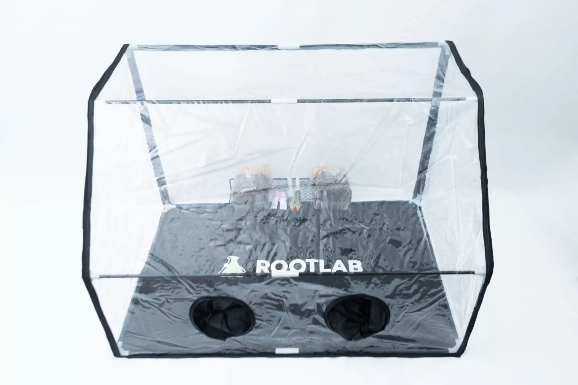 Rootlab Still Air Box with angled viewing window- XL 2 A transparent rectangular enclosure with a black base labelled ROOTLAB. The enclosure has clear walls, two round black openings at the front, and some small objects inside, against a plain white background.