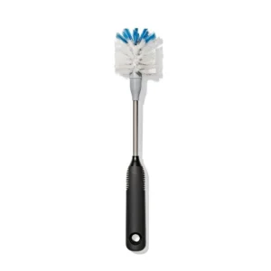 A bottle brush with a black handle, a metal shaft, and white bristles tipped with blue, photographed on a white background.